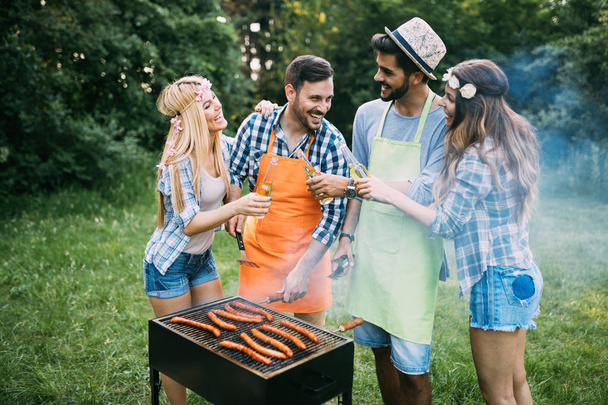 Cheerful friends spending time in nature and having barbecue - Photo, Image