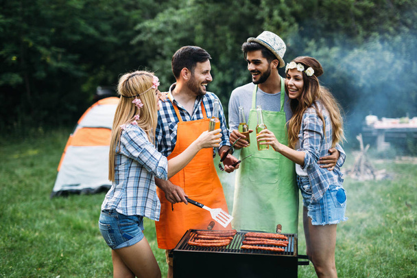 Cheerful friends spending time in nature and having barbecue - Foto, immagini