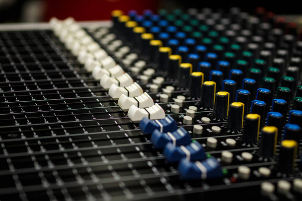 Console de mixage audio professionnelle Faders, bureau noir et contrôleur blanc Faders avec boutons aux jaunes et bleus - Photo, image