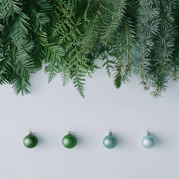 Diseño creativo de mesa de Navidad hecho de ramas de árbol de invierno y decoración de bauble de Año Nuevo en colores verdes
  - Foto, Imagen