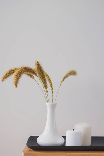 Dry ears in the vase and candles on the small table. - Foto, immagini
