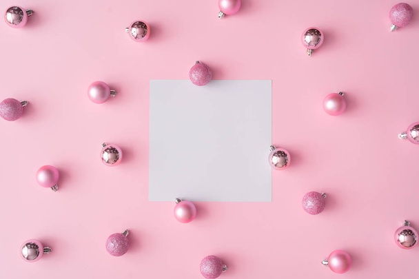 Twórczy skład Christmas karty papieru na centrum i kulki na tle różowy pastelowy kolor. Koncepcja nowego roku   - Zdjęcie, obraz