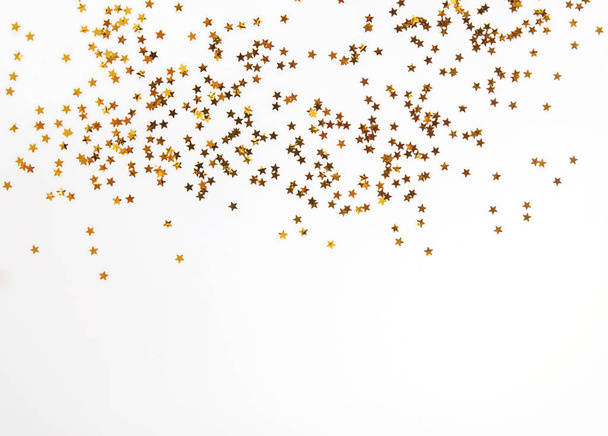 Golden glitter decor on the white background with copy space - Foto, Imagen