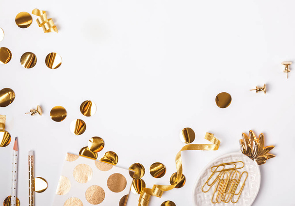 Golden color decor and confetti on the white background - Фото, изображение