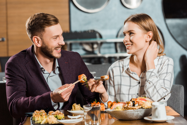 Ελκυστικό χαμόγελο ζευγάρι που έχοντας το γεύμα στο εστιατόριο  - Φωτογραφία, εικόνα
