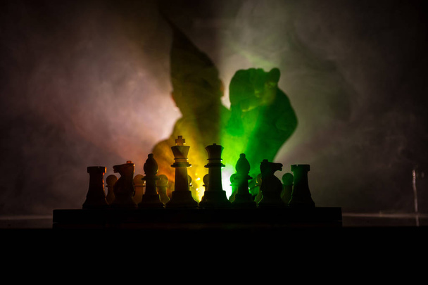 Homme jouant aux échecs. Effrayante silhouette floue d'une personne à l'échiquier avec des figures d'échecs. Fond sombre et brumeux. Concentration sélective. Concept d'horreur
 - Photo, image