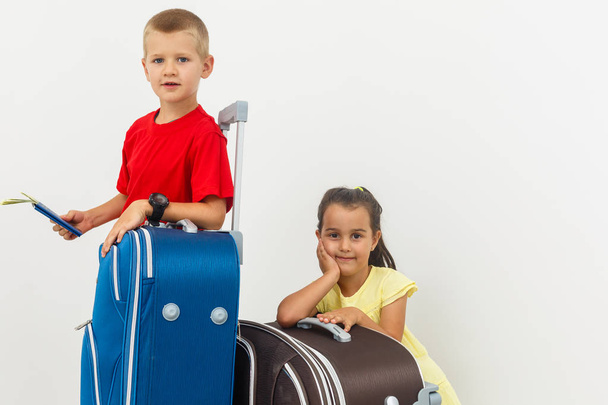 Irmão e irmã com bagagem de viagem posando no fundo branco
  - Foto, Imagem