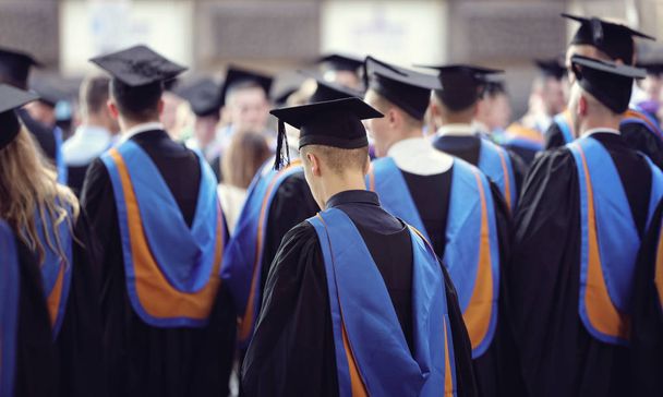 Absolventi na Promoce absolventů univerzity slavnostní pokrývka hlavy a šaty - Fotografie, Obrázek