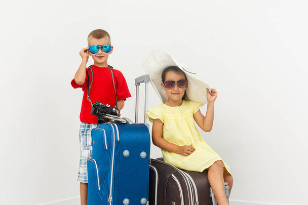 Hermano y hermana con equipaje de viaje posando sobre fondo blanco
  - Foto, Imagen