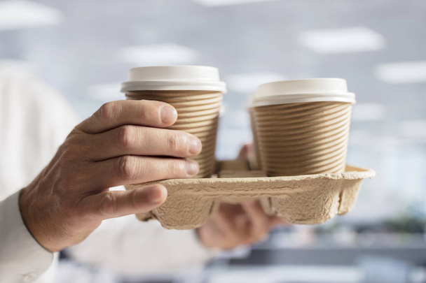Businessman carrying coffee take out disposable cups for office meeting - Fotoğraf, Görsel