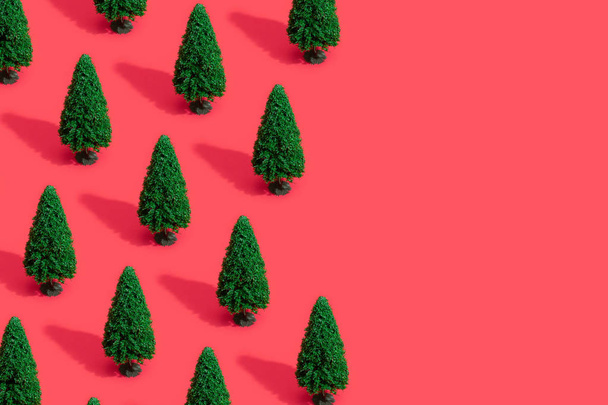 Modèle de composition minimal avec des arbres de Noël verts sur fond rouge pastel. Concept Nouvel An
  - Photo, image