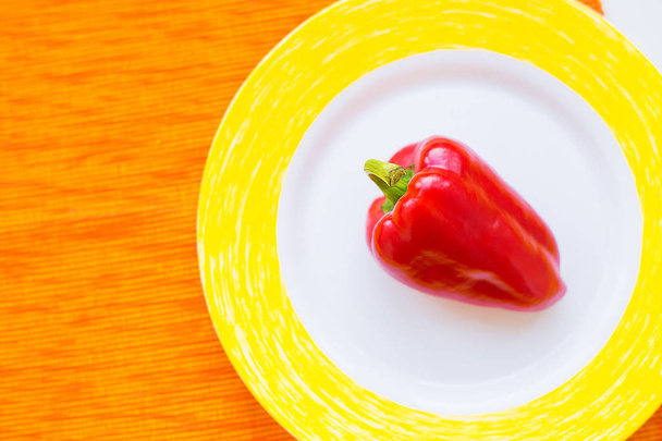 un pimiento rojo en un plato colorido primer plano
 - Foto, imagen