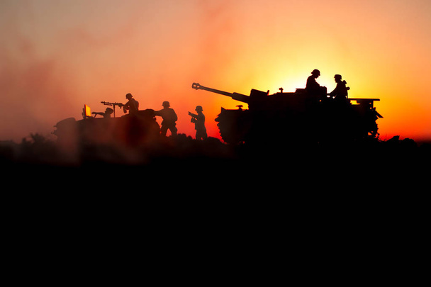 War Concept. Military silhouettes fighting scene. World War German Tanks and soldiers silhouettes at sunset. Attack scene. Armored vehicles. Tanks battle - Фото, изображение