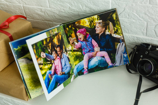Οικογενειακό βιβλίο φωτογραφιών που βρίσκεται σε λευκό τραπέζι - Φωτογραφία, εικόνα