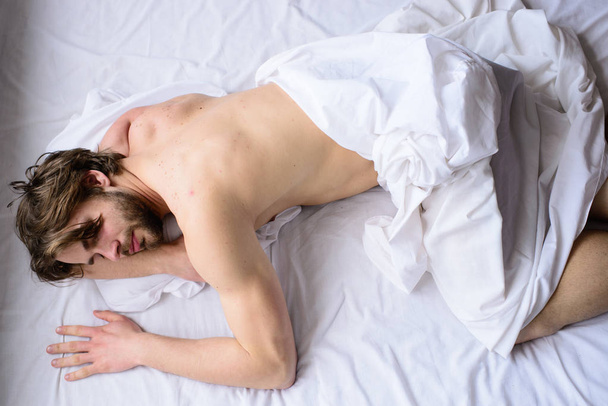 Nechte své tělo cítit pohodlně. Muž neoholený fešák nahý trup spánku nap na posteli pohled shora. Člověk ospalý zarostlý vousatý obličej má odpočinek. Spát v pohodlné matrace a polštáře. Čas pro architekturu nap - Fotografie, Obrázek