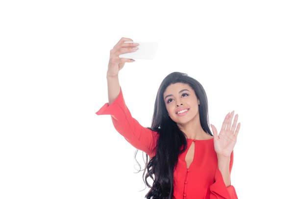 白で隔離のスマート フォン selfie をとり、手で振っている赤いドレスのアフリカ系アメリカ人の笑顔 - 写真・画像