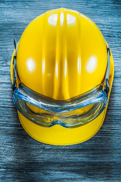 Safety building helmet goggles on vintage wooden board. - Φωτογραφία, εικόνα