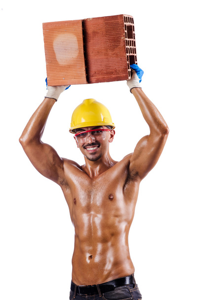 Muscular builder with bricks on white - Photo, Image