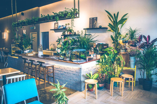 schönes Café mit Tisch, Stühlen und Pflanzen - Foto, Bild