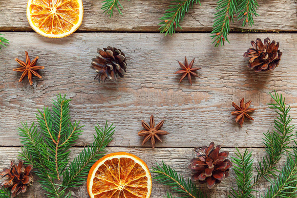Christmas New Year composition winter objects fir branch pine cones orange slices on old shabby rustic wooden background. Xmas holiday december decoration. Flat lay top view. Time for celebration - Photo, Image