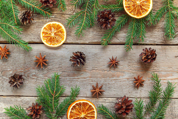 Christmas New Year composition winter objects fir branch pine cones orange slices on old shabby rustic wooden background. Xmas holiday december decoration. Flat lay top view. Time for celebration - Photo, Image