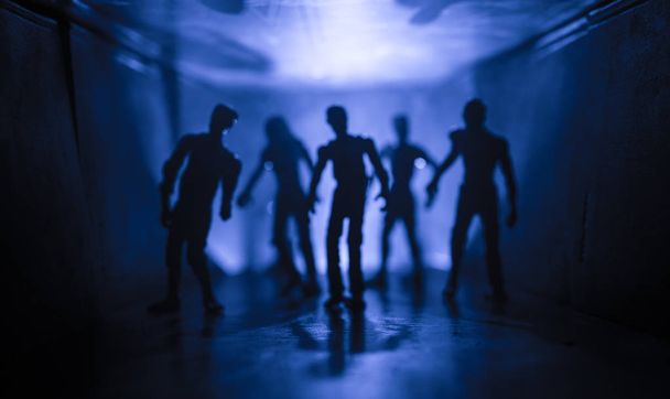 Silhouette effrayante dans le bâtiment sombre abandonné. Le concept d'apocalypse zombie ou couloir sombre avec des silhouettes de zombies d'horreur effrayants debout avec différentes poses
. - Photo, image