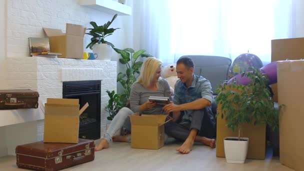 Giovane coppia mettere album di famiglia in scatola di cartone mentre seduto sul pavimento a casa
 - Filmati, video