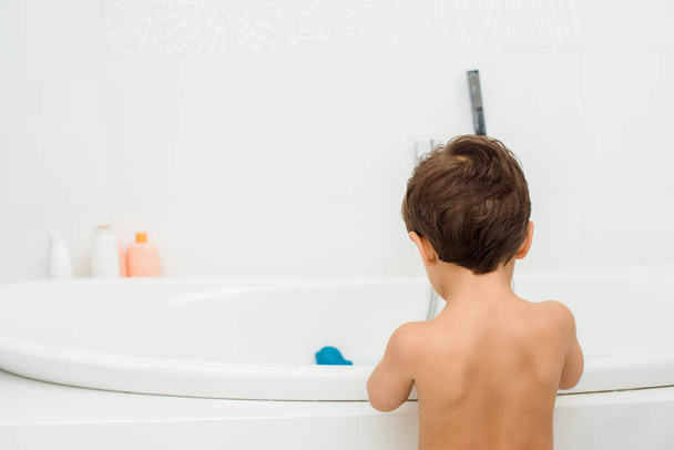 Naked toddler boy standing in white bathroom - Foto, afbeelding