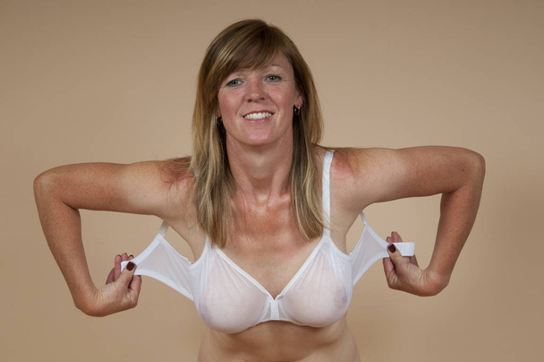 Blonde woman fastening bra - Photo, Image
