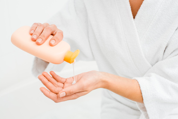 Close up van vrouw lotion knijpen in hand geïsoleerd op wit - Foto, afbeelding