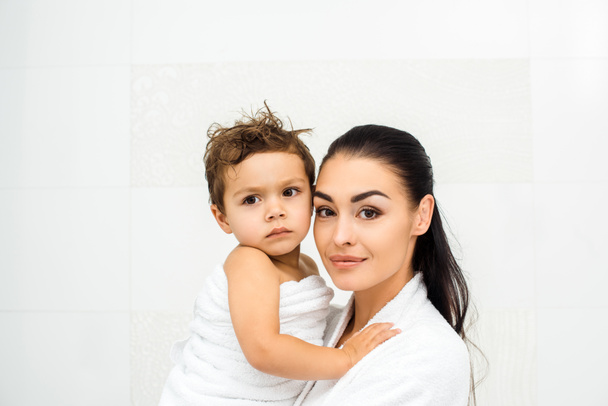 Close up of mother holding toddler son on white - Foto, imagen