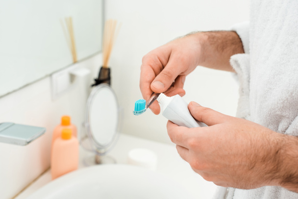 a férfi kezei fogkrém és fogkefe közel mosogató közelről - Fotó, kép