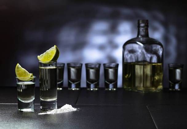 Small glasses of tequila and lime slices. - Photo, Image