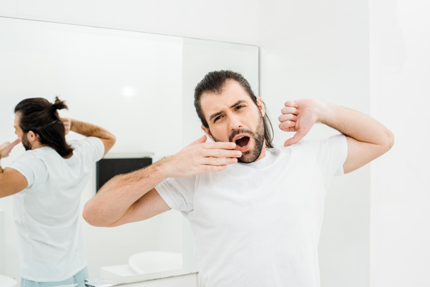 Człowiek w T-shirt, rozciąganie i ziewanie w łazience białe - Zdjęcie, obraz