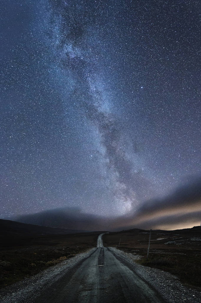Vía Láctea sobre la carretera en Stugudalen cerca de las montañas Sylan, Noruega. Cielo nocturno otoñal
. - Foto, Imagen