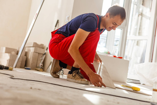 Young man installing ceramic floor tiles - Photo, Image