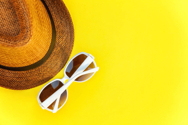 Flat Lay con gafas de sol y sombrero retro sobre fondo de moda moderna de color amarillo. Vacaciones verano fin de semana mar aventura viaje concepto
 - Foto, imagen
