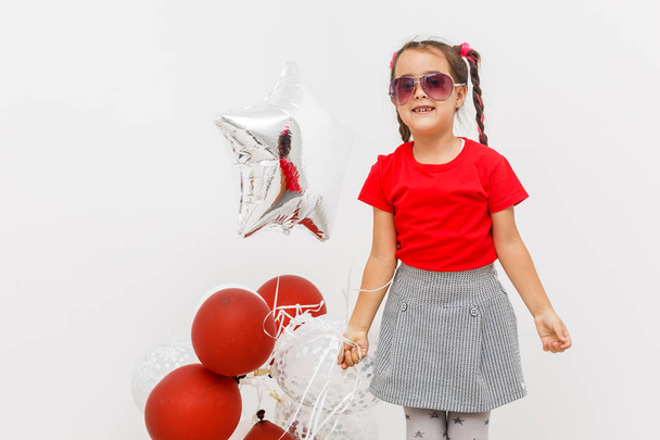 радостная маленькая девочка с кучей разноцветных воздушных шаров
 - Фото, изображение
