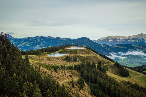 зеленый холм и далекие скалистые горы под голубым небом
 - Фото, изображение