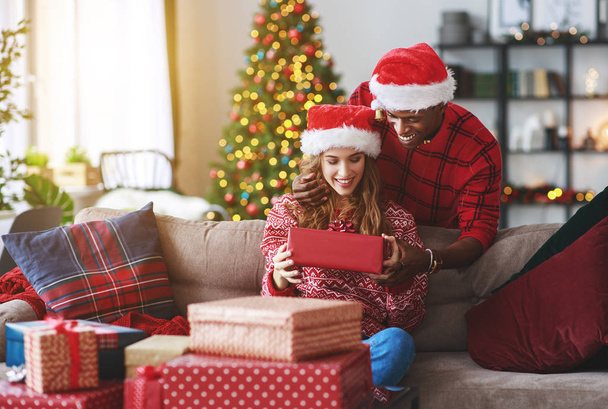 счастливая молодая пара открывает подарки на Рождество утром
 - Фото, изображение