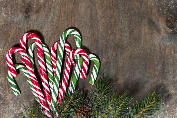 assortment of christmas sugar candies and fir branches on grey wooden background, closeup top view - Valokuva, kuva