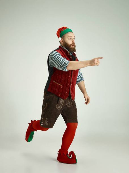 friendly man dressed like a funny gnome posing on an isolated gray background - Fotoğraf, Görsel
