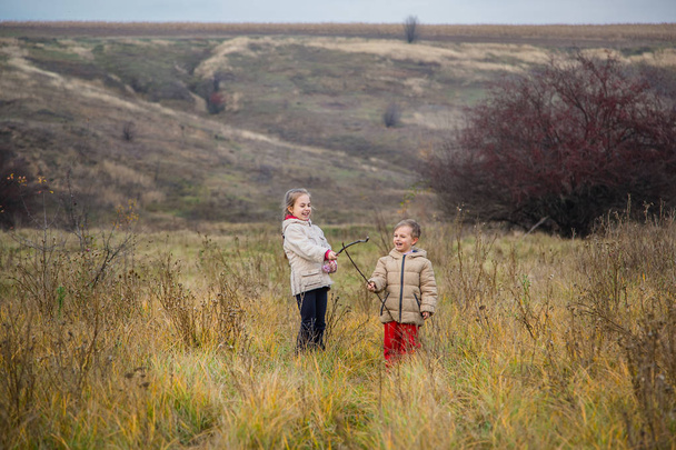 Gyermekek befut a mezőt. Gyermekek játszanak a mező az arany óra. Ragyogó őszi színek. - Fotó, kép