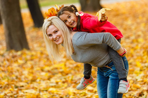 Мать и дочь веселятся в осеннем желтом парке
 - Фото, изображение