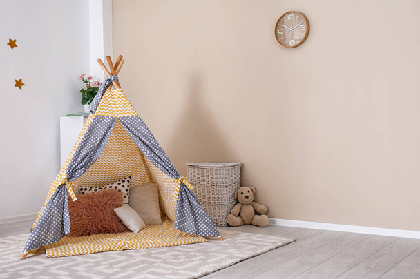 Cozy kids room interior with play tent and toys. Space for text - Foto, Imagen