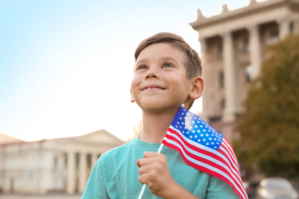 Cute little boy with American flag on city street - Foto, afbeelding