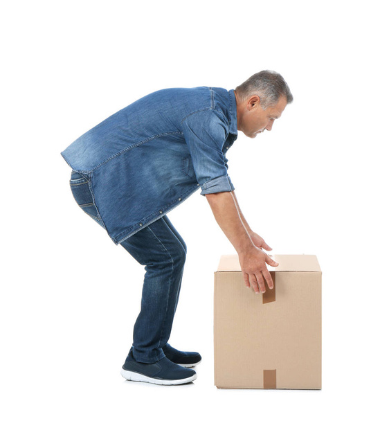 Full length portrait of mature man lifting carton box on white background. Posture concept - Valokuva, kuva