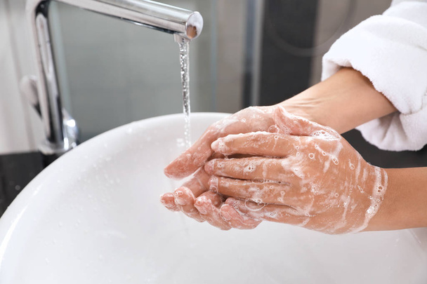 Woman washing hands with soap over sink in bathroom, closeup - Φωτογραφία, εικόνα