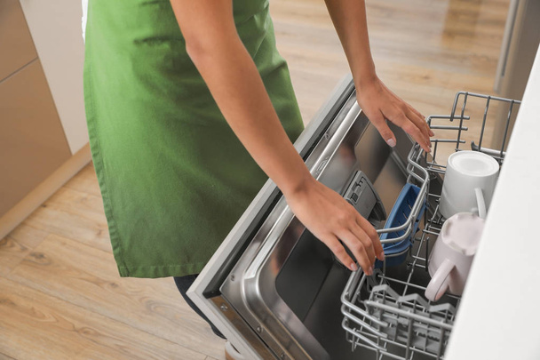 Woman opening dishwasher in kitchen, closeup. Cleaning chores - Fotoğraf, Görsel