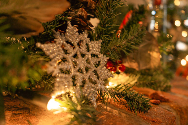 Hópehely dísz dísz tégla kandalló a karácsonyi fények háttérrel - Fotó, kép